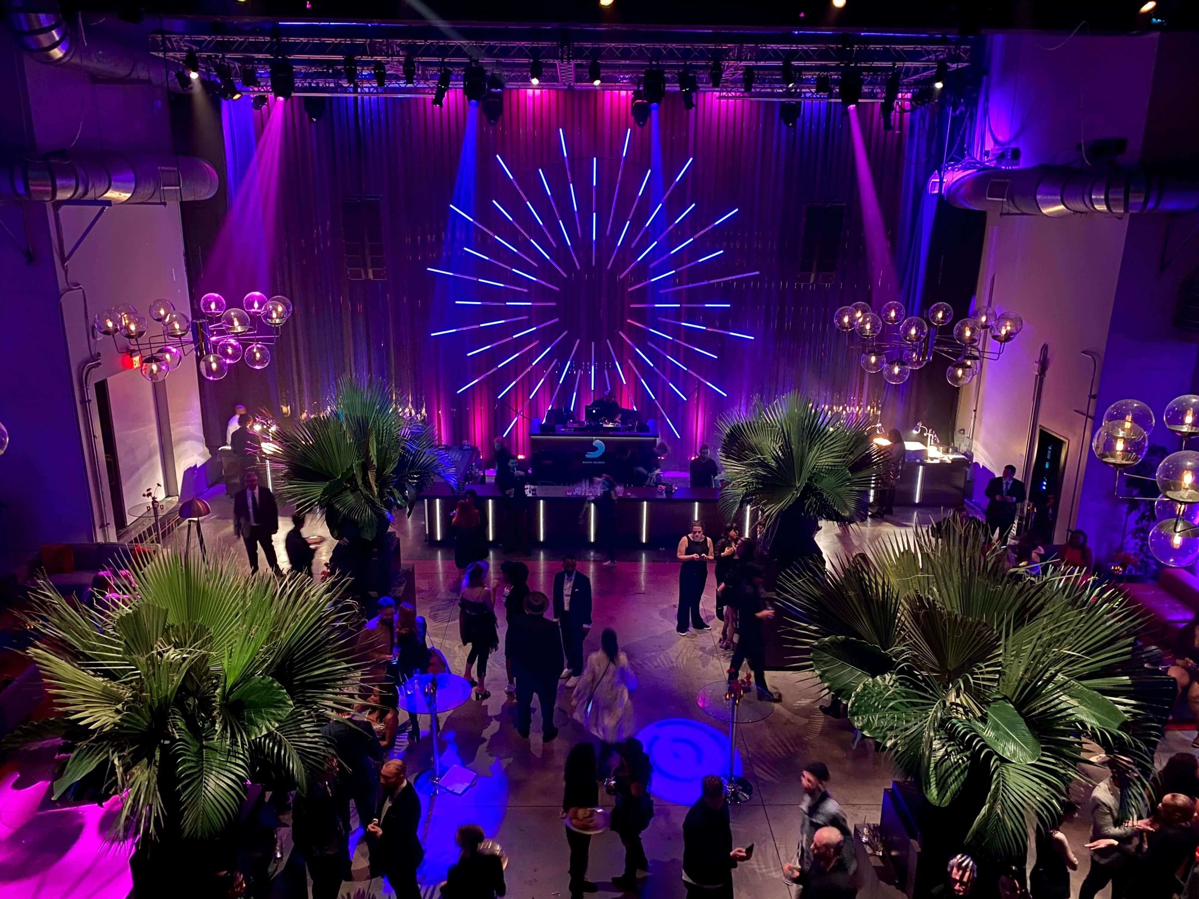 Purple and cyan beams cutting through a Sony live event